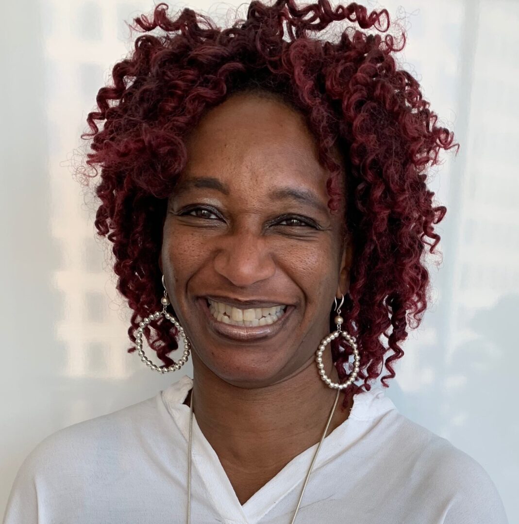 A woman with red hair smiling for the camera.