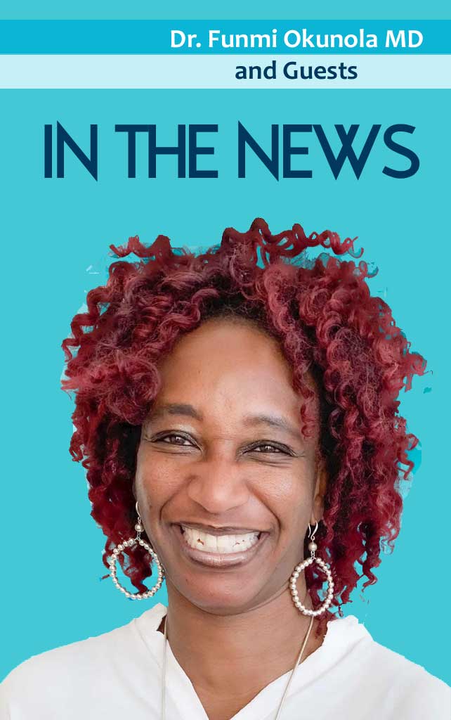 A woman with red hair and earrings smiling.